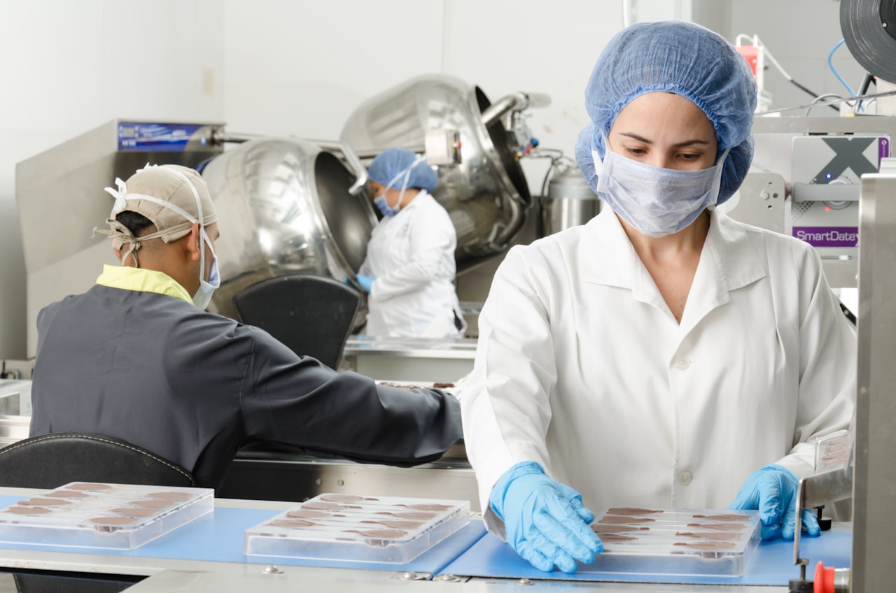 Técnicos en planta de alimentos con equipo de protección